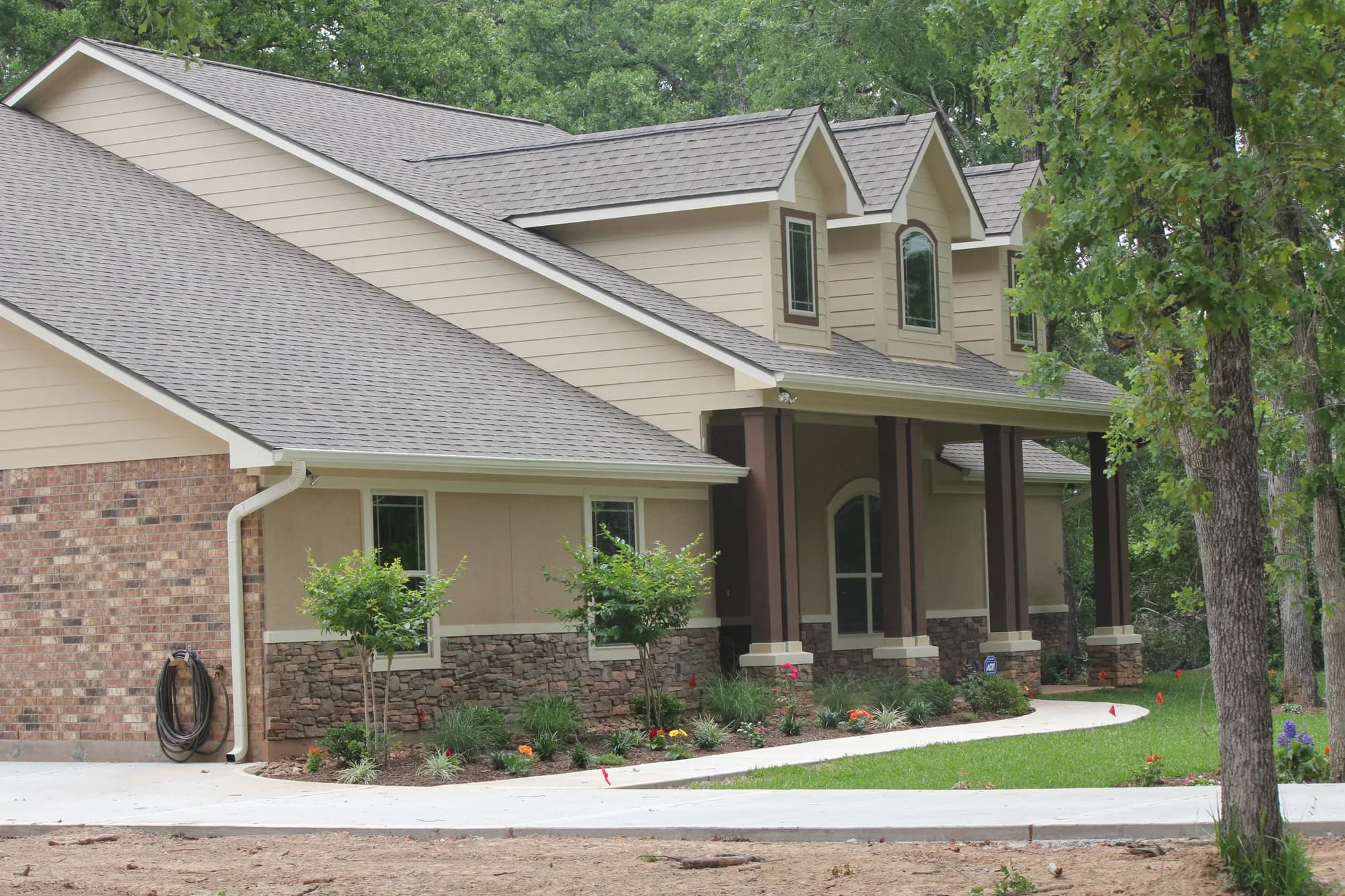 Stone and siding custom home with a covered front porch built by QBS